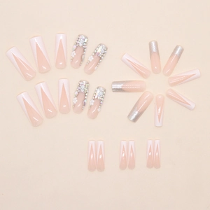 Detailed flat lay of pink coffin press-on nails with 3D white flowers and rhinestones