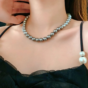 Close-up of elegant grey pearl necklace worn on model neck for minimalist styling