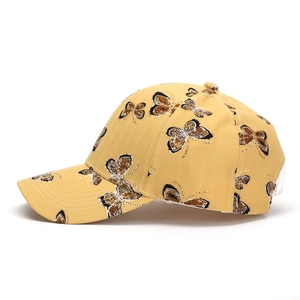 Vue latérale d'une casquette de baseball jaune avec imprimés papillon et visière courbée