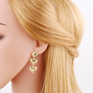 Elegant gold heart drop earrings with three dangling tiers and shimmering zircon stones