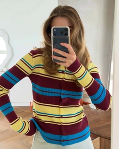 Detail of colorful striped rib-knit cardigan with round neck and small buttons