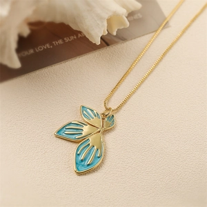 Chic gold-plated necklace with blue enamel petal pendant on a textured beige surface