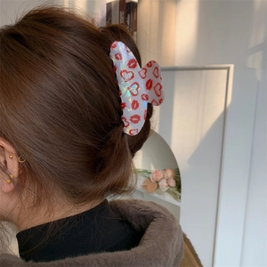 Model showing medium heart and red lips print hair claw clip on brunette hair