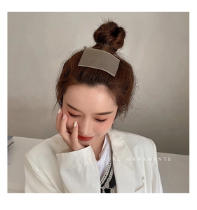 Macro detail of square ribbed hair clip in matte khaki finish on an elegant hairstyle