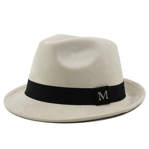 Macro detail of silver M logo on gray suede fedora hat with black ribbon band