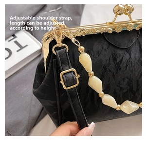 Detail of adjustable black strap with gold buckle on a beaded shell clutch bag
