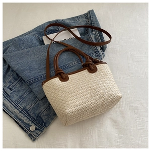 Minimalist woven straw crossbody tote bag with brown faux leather trim and handles