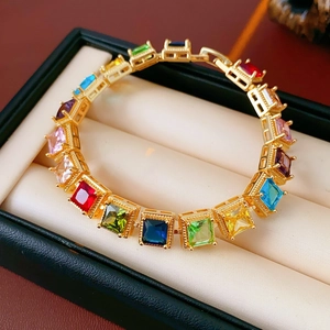 Détail macro du bracelet vintage doré serti de zircons carrés multicolores