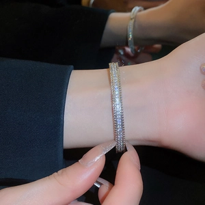 Close-up of luxury gold-plated bangle featuring layered zircons and beaded edge detail