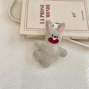 Close-up of pink and green plaid rabbit plush pendant with detailed embroidery and chain