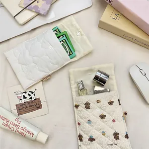 Quilted storage pouch for sanitary pads with cute puppy print and button closure