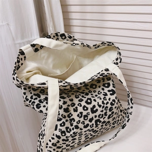 Close-up of leopard print canvas tote bag featuring internal pocket and durable strap
