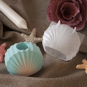 Détail du moule en silicone coquille avec bougie sur fond en tissu texturé