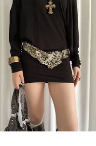 Détail d'une ceinture léopard avec boucle papillon en strass sur une robe noire élégante