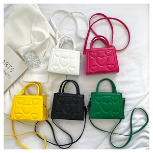 Détail de cinq mini sacs carrés avec texture gaufrée en cœur dans divers coloris tendance