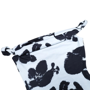 Detail of the chic cow print dress featuring a twist knot neckline and ruched texture