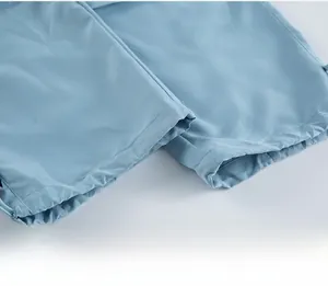 Dettaglio dei pantaloni cargo azzurri con polsini elastici e doppia cucitura rifinita