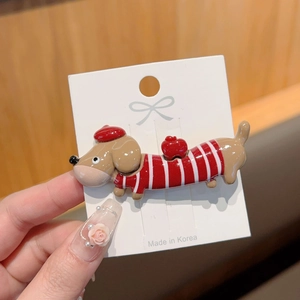 Detail of dachshund hair clip with red beret and striped sweater in hand close-up