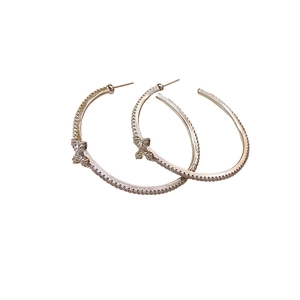 Minimalist silver hoop earrings with shimmering zircons and small cross charm detail