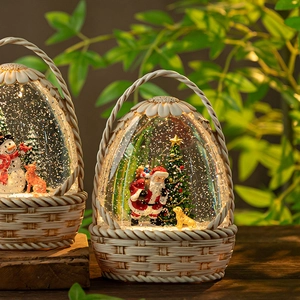 Christmas snow globe lanterns with Santa and snowman motifs in warm yellow glowing basket