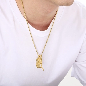 Detailed view of gold snake pendant with red stone eyes on a twisted rope chain necklace