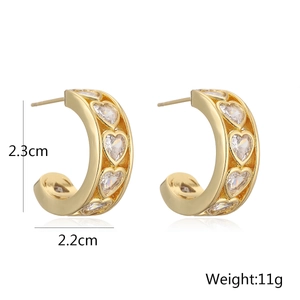 Detailed view of 18K gold plated C-shaped earrings with heart-cut cubic zirconia inlays