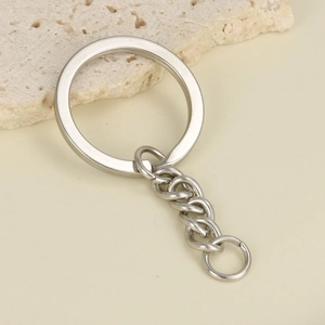 Detail view of 18K gold plated stainless steel key ring and chain on a stone texture
