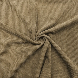 Detailed close-up of khaki corduroy fabric showing thick vertical ribbed texture and softness
