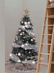 Detail showing the lit LED starry string lights and white mesh ribbon on the Christmas tree