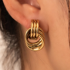 Elegant geometric gold knot hoop earrings in stainless steel for women on a model