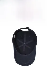 Detail view of cotton baseball cap interior showing 100% cotton label and frayed brim