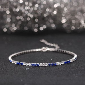 Detailed close-up of 2mm silver tennis bracelet with blue and white stones on black background