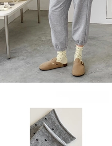 Detail of knit cotton crew socks featuring cream black polka dots and rolled cuff edges