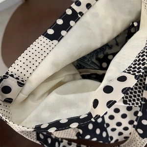 Dettaglio della borsa in tela a pois bianchi e neri con fodera bianca e cuciture resistenti