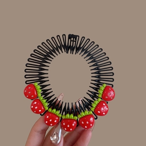 Detail of red strawberry circular hair comb clip for girls with flexible black teeth