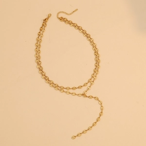 Dettaglio di una collana dorata a due strati con maglie a naso di maiale e catenina