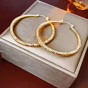 Vue détaillée de créoles dorées avec texture diamantée sur un coffret à bijoux
