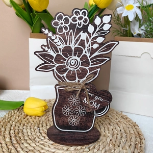 Detail of wooden flower mug ornament with heart tag saying Love You Mom on woven mat