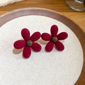 Detailed view of dark red velvet flower earrings with smooth brown bead centers