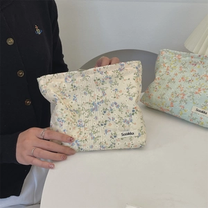 Close-up of floral canvas toiletry bags with zipper and woven label detail