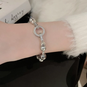 Detailansicht eines Silberarmbands mit grauen Perlen und Strassbesatz am Handgelenk