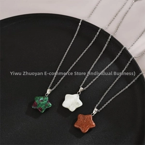 Macro detail of three star-shaped stone necklaces on a sleek black display tray