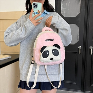 Pink and white plush panda backpack for kids shown on a model in a cozy indoor setting