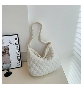 Detail of white quilted cloud bag with soft padded texture and integrated shoulder strap