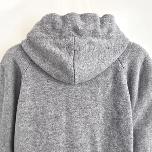 Back view of women's grey hooded knitted jacket with casual long sleeves and clean texture