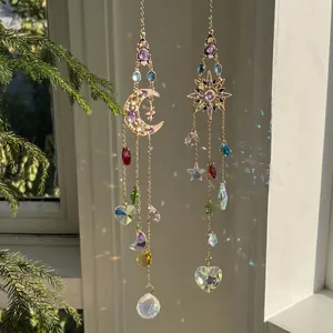 Golden moon and sun crystal suncatchers with rainbow refraction on window background