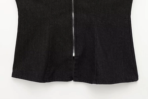 Dettaglio del top in denim nero con cerniera in metallo argentato di alta qualità
