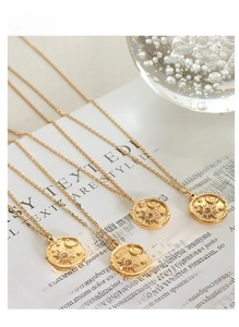 Detail of gold sun and moon pendants with zircons on aesthetic background paper