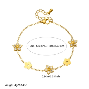 Gold plated stainless steel flower charm bracelet with crystals on a white background
