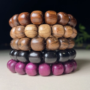 Detail shot of assorted sandalwood barrel beads showing natural wood grain and textures